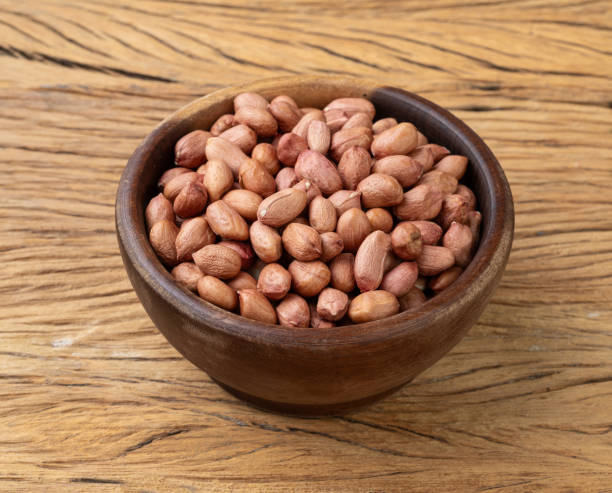 istock Raw peanuts in a bowl over wooden table 1867398587
