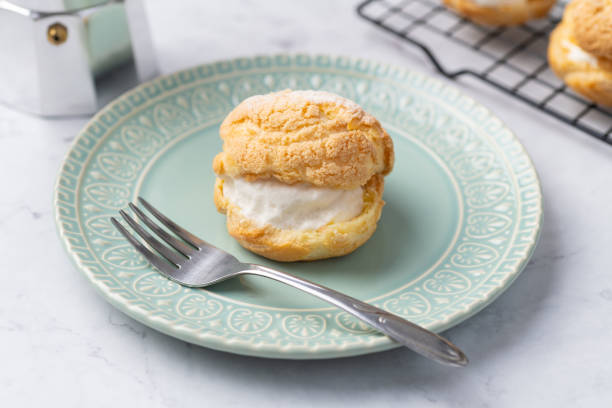 istock Choux cream, vanilla whipped cream stuffed cake on a green plate 1867399099