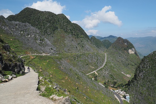Ha Giang, Vietnam – 10.16.2023: Motorcyclist riding the winding roads on the Ha Giang Loop through the mountains of northern Vietnam