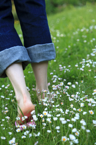 A woman walking through a daisy meadow. Nice spring/summer background. Shallow depth of field.