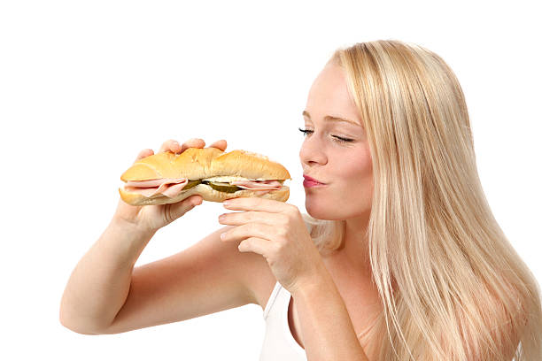 istock Young woman eating sandwich 186744076