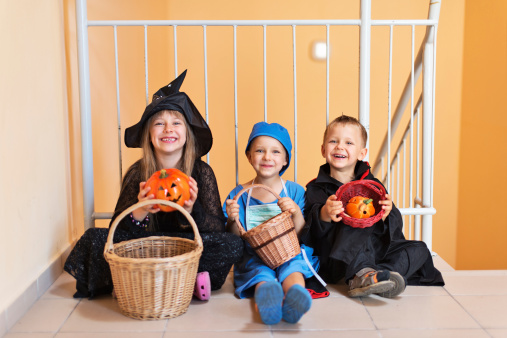 Helloween kids resting on a staircase.