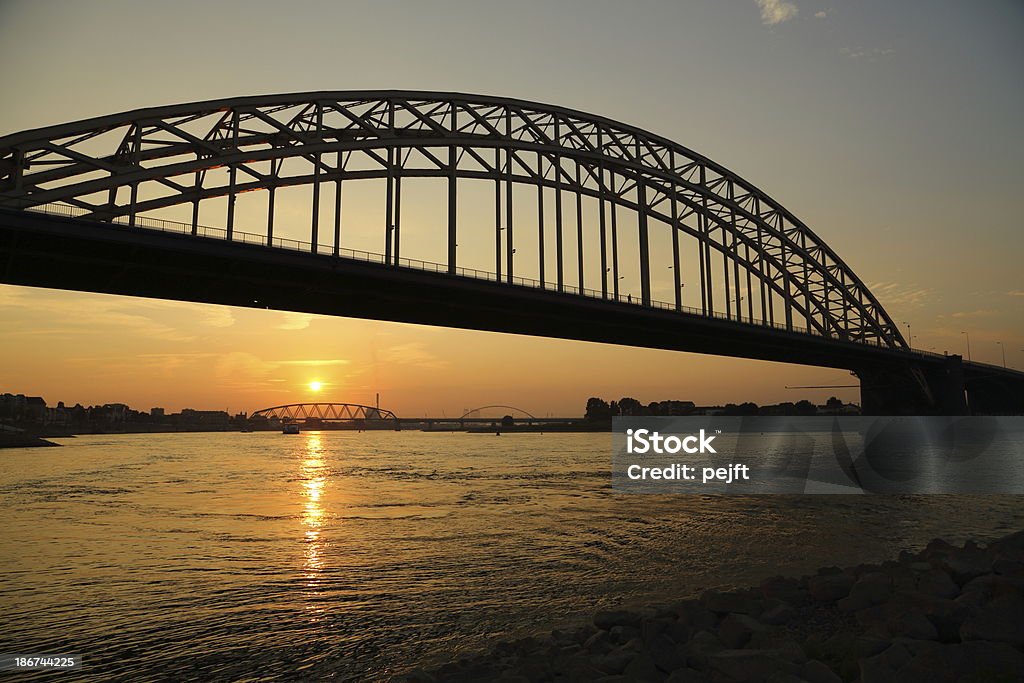 Nijmegen Most drogowy w Zachód słońca - Zbiór zdjęć royalty-free (Barka - Statek przemysłowy)