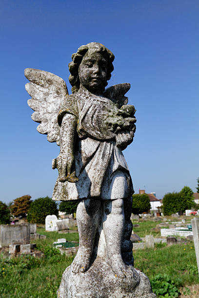 istock Grubby child angel dropping petals on grave 186744246