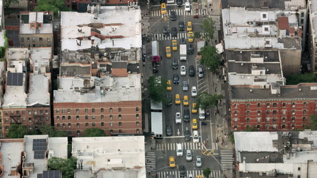 AERIAL Above a street in Manhattan with a lot of taxi cars driving down the street