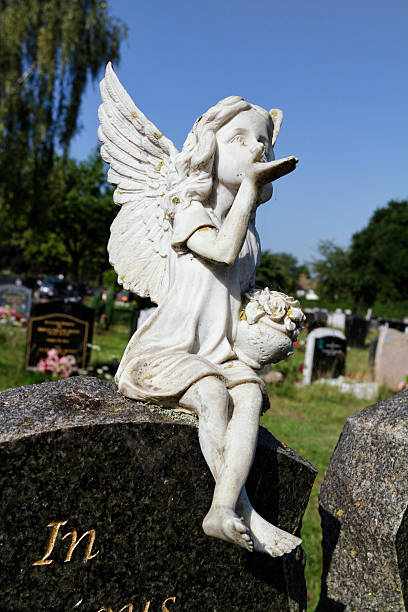 istock Cheeky winged cherub blows kiss from gravestone 186745469