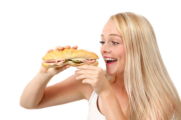 istock Young woman eating sandwich 186745704