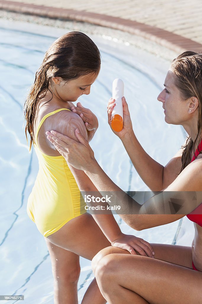 Mãe e filha usando protetor solar, piscina - Foto de stock de Protetor Solar royalty-free