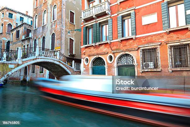 Boat Passing By The Bridge Along A Canal In Venice Stock Photo - Download Image Now - Blurred Motion, Bridge - Built Structure, Building Exterior