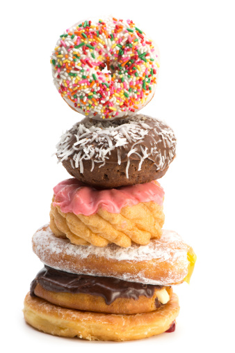 A stack of six decorated donuts on a 255 white background.