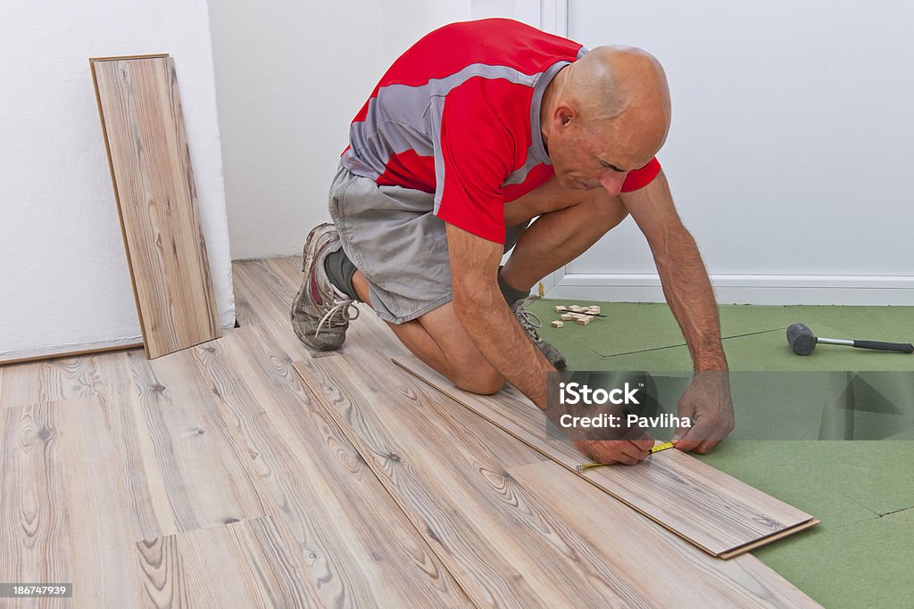 Installation de plancher en bois au cours de travaux d'agrandissement - Photo de Adulte libre de droits