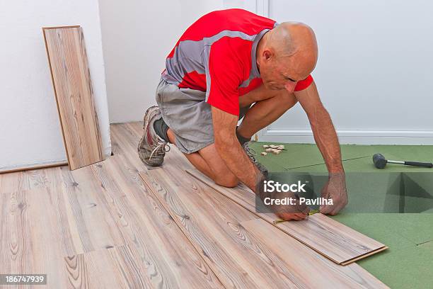 Photo libre de droit de Installation De Plancher En Bois Au Cours De Travaux Dagrandissement banque d'images et plus d'images libres de droit de Adulte