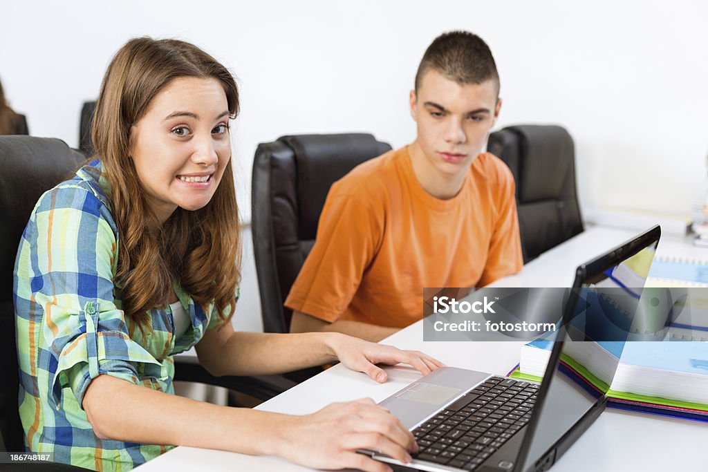 Teenage girl shrugging while using laptop Teenage girl shrugging while using laptop at school. Shrugging Stock Photo