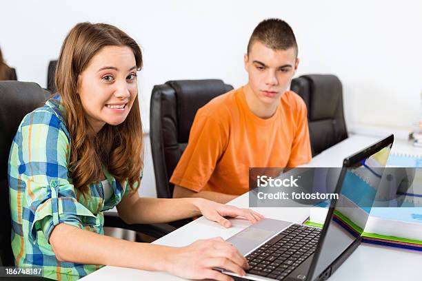 Teenage Girl Shrugging While Using Laptop Stock Photo - Download Image Now - Shrugging, Student, Classroom