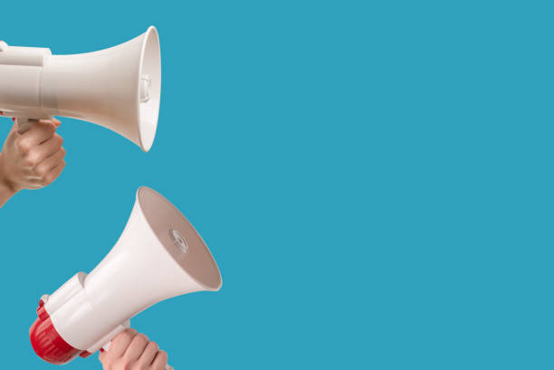 istock Megaphone in woman hands on a blue background. 1867484202