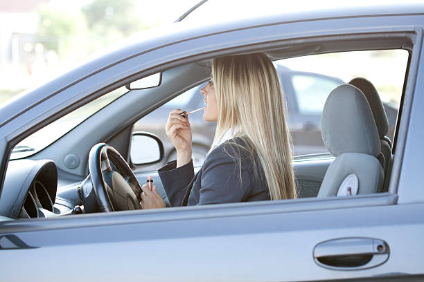 istock woman applying lipstick in car 186748615