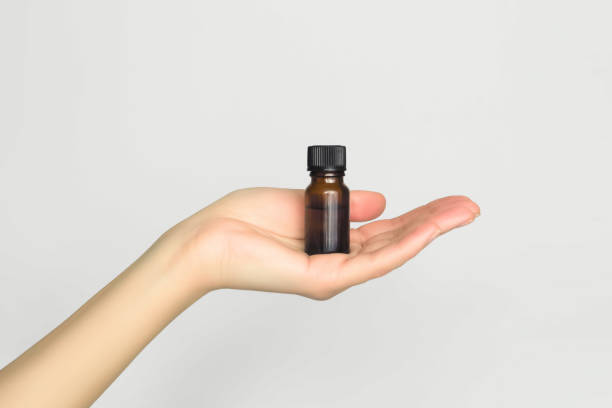 istock hand holding a glass bottle with essential oil 1867487855