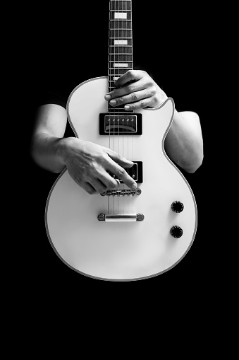 BW male musician posing on white electric guitar, isolated on black. music background