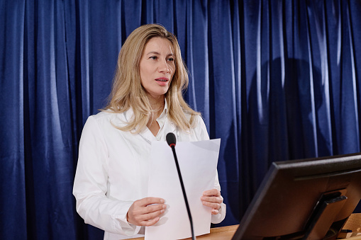 Professional doctor presenting her report to colleagues at conference