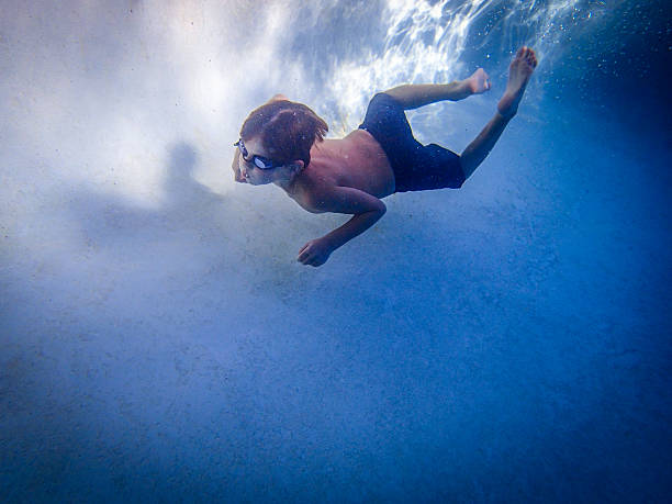 istock Free diving boy in pool swimming 186749577