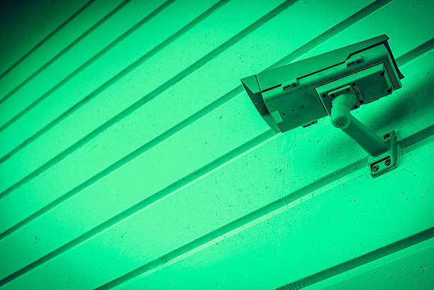 Infrared view of security camera on striped copy space wall.