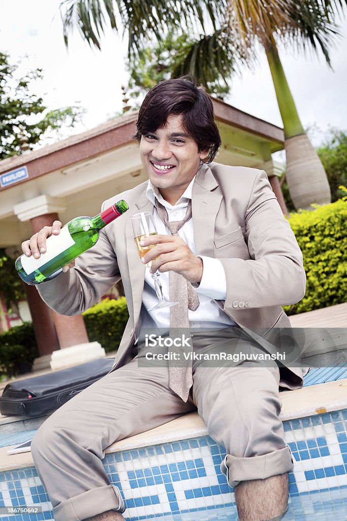 Молодой веселый Индийский бизнесмен расслабляющий в плавательный бассейна - Стоковые фото 20-29 лет роялти-фри