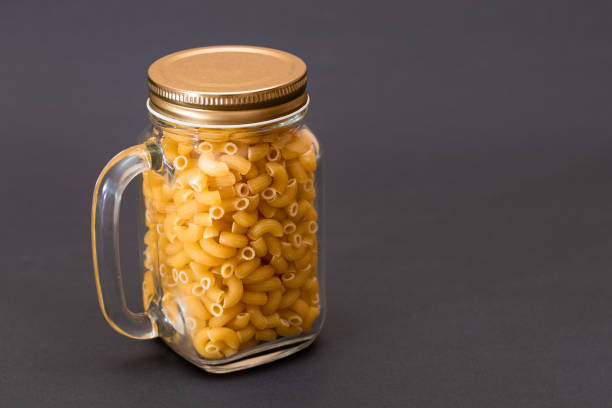 istock Uncooked Chifferi Rigati Pasta in Glass Jar on Black Background 1867510287