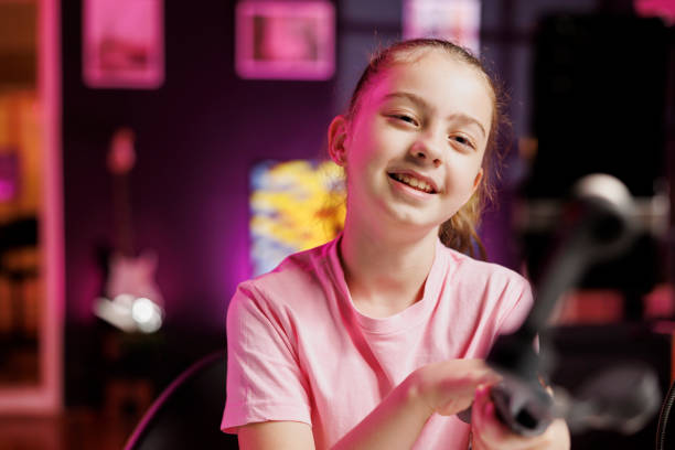 istock Smiling girl filming room tour inside home studio using cellphone on selfie stick 1867518199