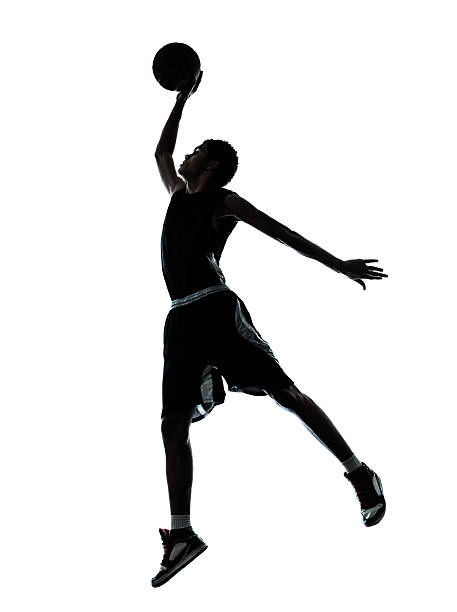 Silhouette of a basketball player dunking one young man basketball player dunking silhouette in studio on white background silhouette of basketball player slam dunk stock pictures, royalty-free photos & images