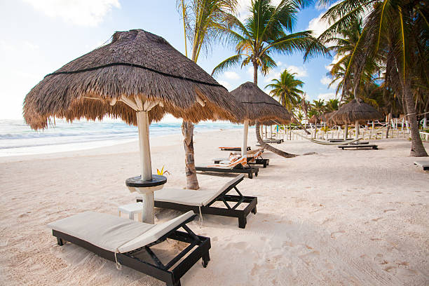istock Chaise lounges under an umbrella on white sandy beach 186753981