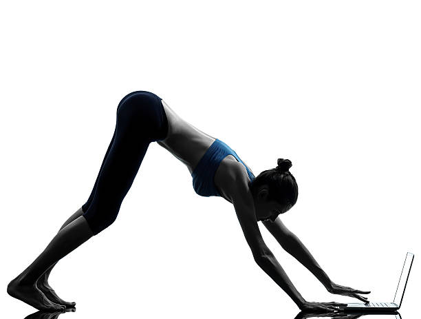 istock woman exercising yoga using computer laptop 186754263