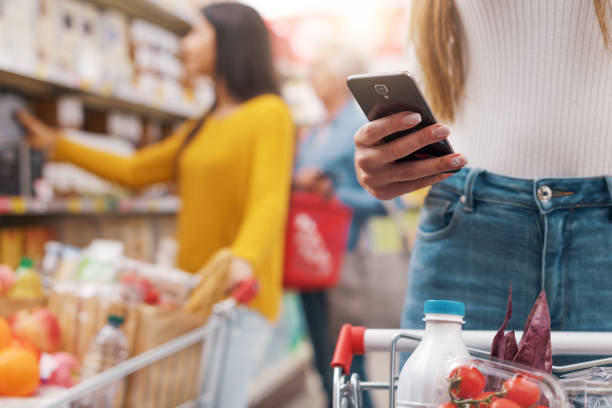 istock Woman using a smartphone at the supermarket 1867545508