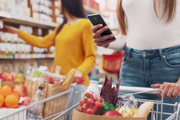 istock Woman using a smartphone at the supermarket 1867547635