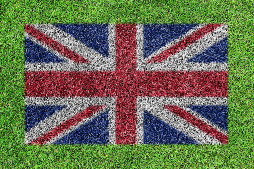 a flag of british as painting on green grass background