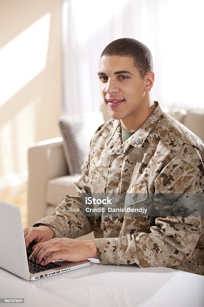 US Marine studyng at home on a laptop US Marine studying at home on a laptop. The model is wearing an official US Marine corps Marpat BDU uniform. 20-24 Years Stock Photo