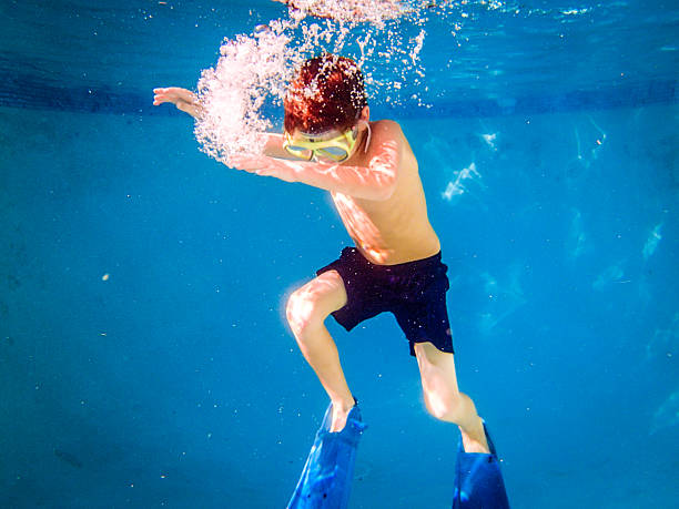 istock Free diving little boy with mask in pool 186759356