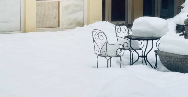 istock Fresh fallen snow on a bistro table and chairs outside 1867601237