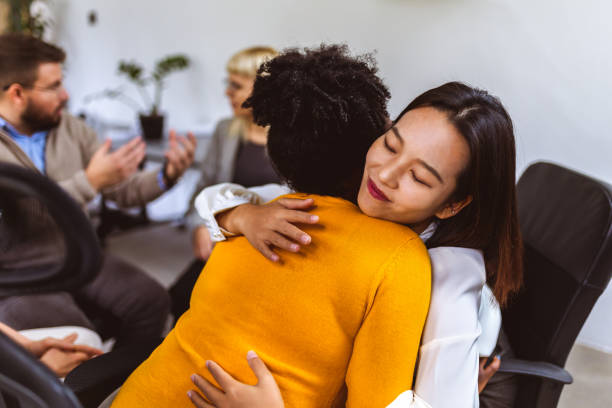 istock Two women hugging at a group therapy session, overcoming problem together 1867611220
