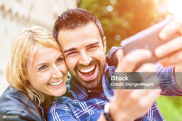 Mid Adultos Pareja Tomando Fotos Con Un Teléfono Inteligente Foto de stock y más banco de imágenes de 25-29 años