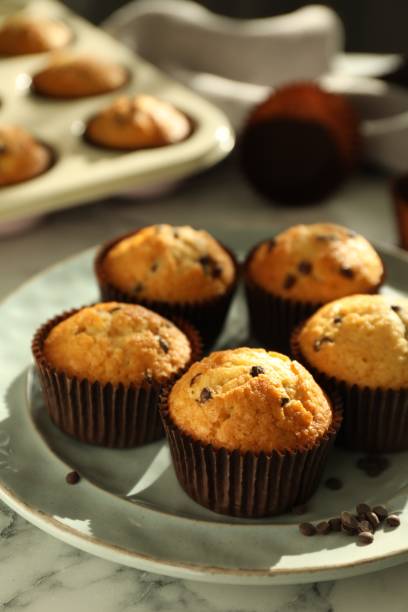 istock Delicious sweet muffins with chocolate chips on white marble table 1867627873