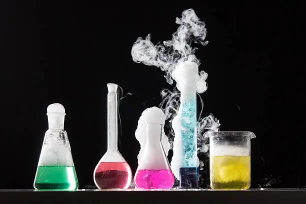 Photo of Four bubbling beakers of colorful liquid