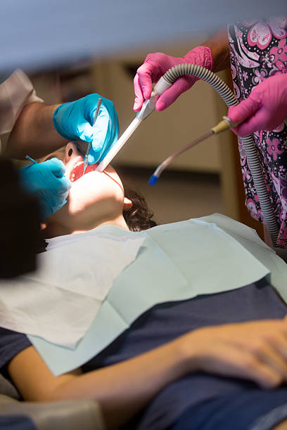 mujer joven obtener un llenado - mouth open dental drill holding doctor fotografías e imágenes de stock