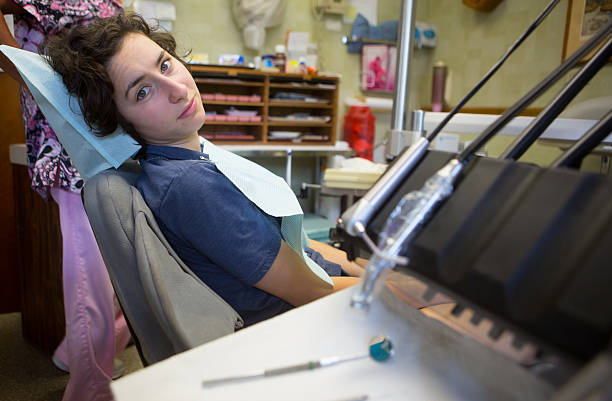 mujer joven obtener un llenado - mouth open dental drill holding doctor fotografías e imágenes de stock