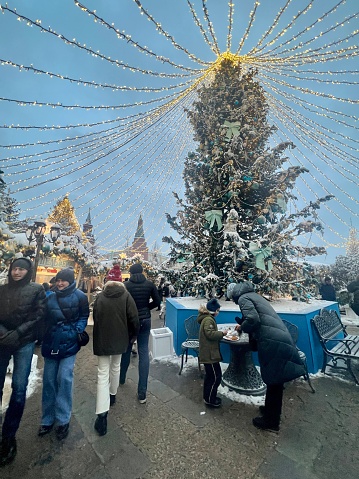 Moscow, Russia - December 16, 2023: Crowds of people enjoying Christmas lights on Moscow streets