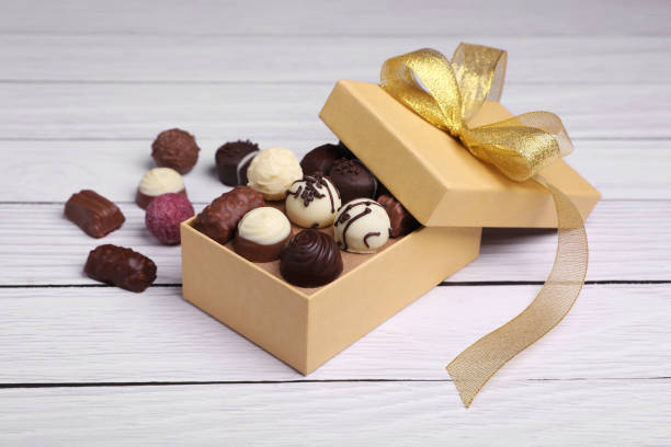istock Box with tasty chocolate candies on white wooden table 1867631123