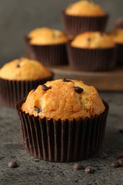 istock Delicious freshly baked muffins with chocolate chips on gray table, closeup 1867631676