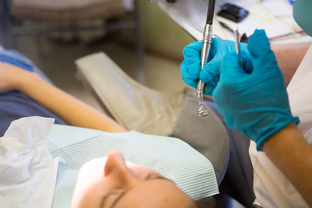 mujer joven obtener un llenado - mouth open dental drill holding doctor fotografías e imágenes de stock