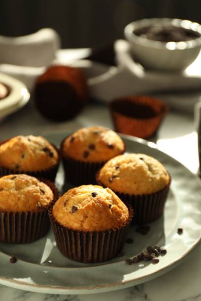 istock Delicious sweet muffins with chocolate chips on white marble table 1867633238