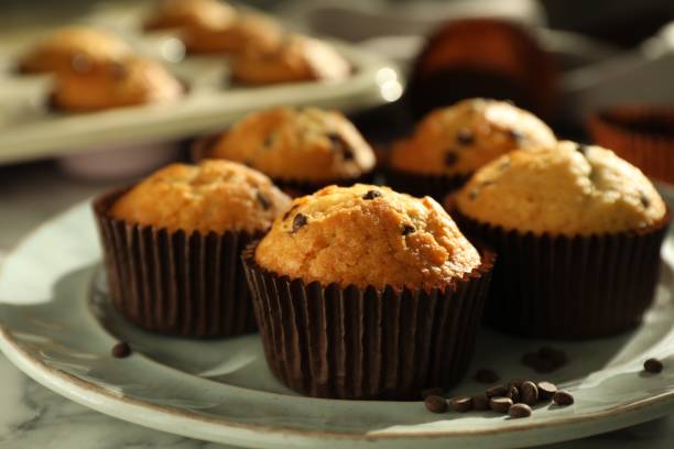 istock Delicious sweet muffins with chocolate chips on white marble table, closeup 1867633239