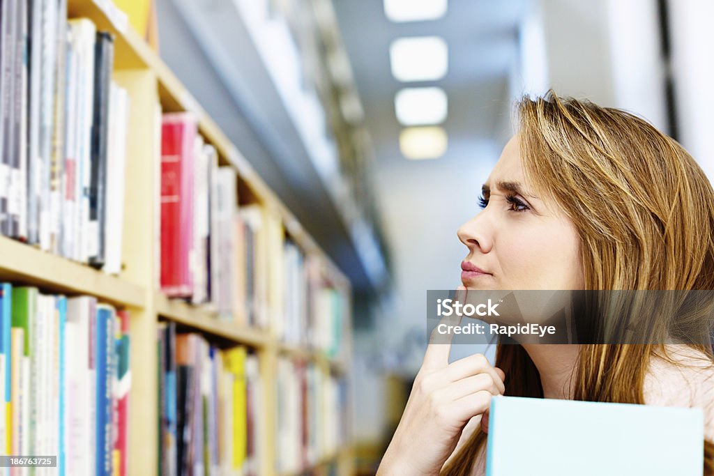 Lo que voy a leer hoy? Hermosa mujer elegir biblioteca de libros - Foto de stock de Biblioteca libre de derechos